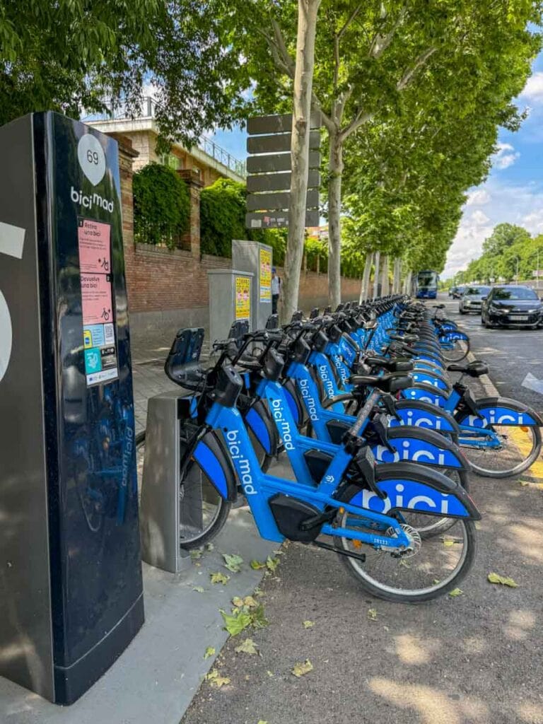 a dock station for Bicimad bicycle rentals with a line of blue bicycles available