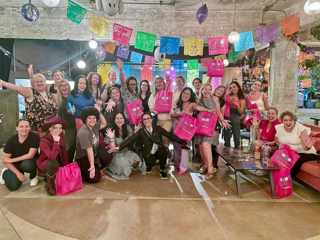 group of women posing under papel picado banners